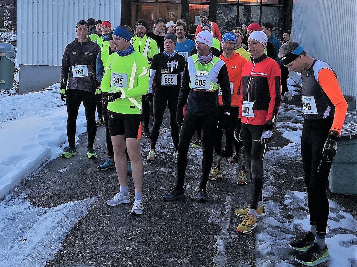 30 løpere, mer eller mindre vinterlig antrukket, gjør seg klare utenfor Prestrudhallen til siste løp forrige sesong. (Foto: Rolf Bakken)