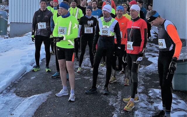 30 løpere, mer eller mindre vinterlig antrukket, gjør seg klare utenfor Prestrudhallen til siste løp forrige sesong. (Foto: Rolf Bakken)