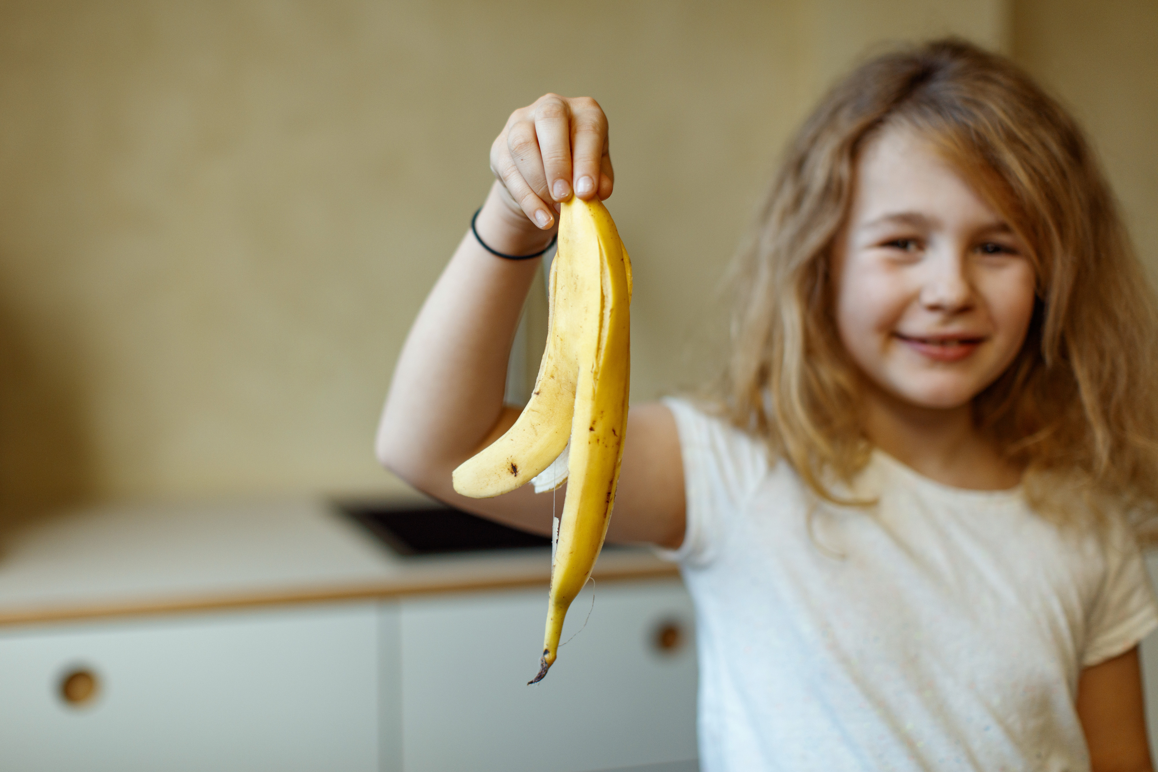 Jente holder frem bananskall