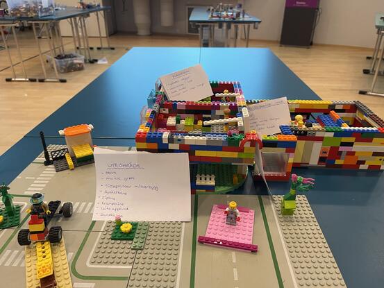 Ein firkanta bygning av lego med uteområde.