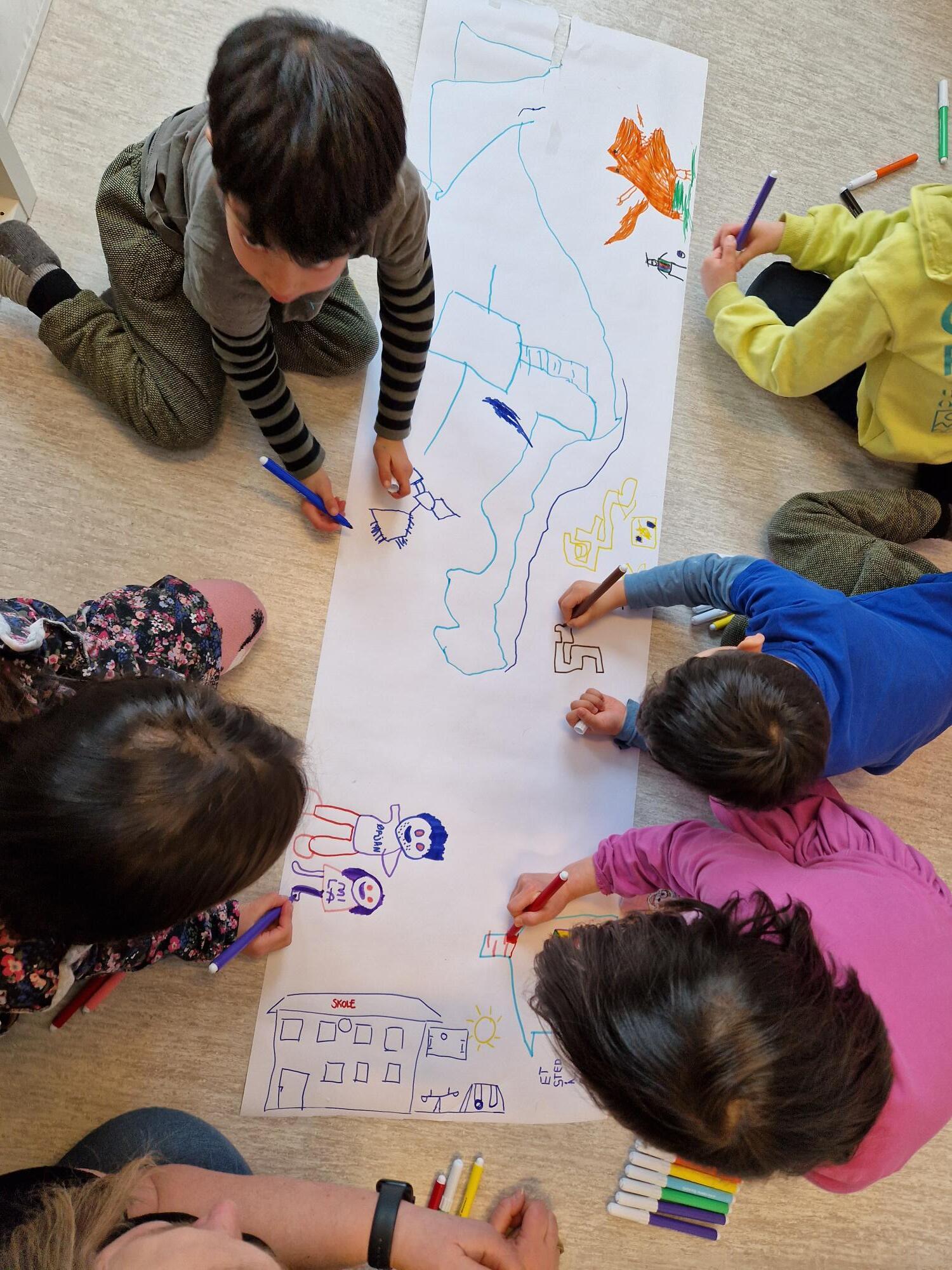 Bilde av barna i Strandvegen barnehage mens de jobber med å lage et fremtidsbilde av hva som kreves for en god oppvekst. 