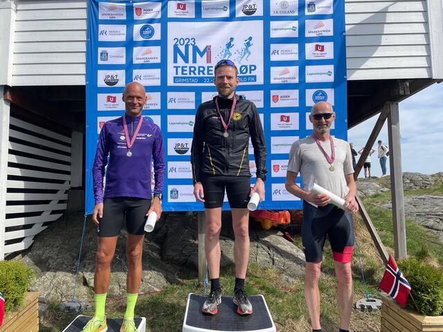Seierspallen i MV50-54 år i terreng-NM kort løype ble besatt av (fra venstre) Erik Bergersen (Kristiansand Løpeklubb), Karl-Olaf Høntorp	(Oppegård IL) og Tellef Dønnestad (Kristiansand Løpeklubb). Foto: Finn Kollstad.