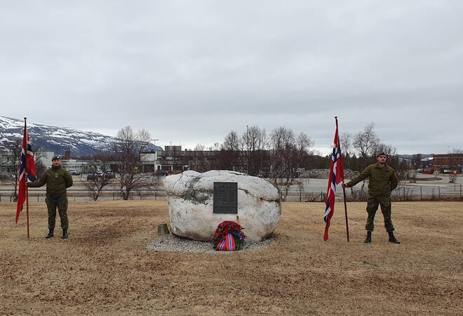 Krans og flaggborg foran minnestenen i Lakselv, fra markeringen i 2023