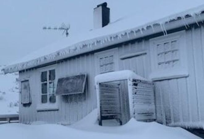 Bilete av ei nedisa hytte på fjellet (illustrasjonsfoto)