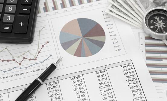 illustrasjon av penn som ligger på et ark med tall i tabell og kakediagram