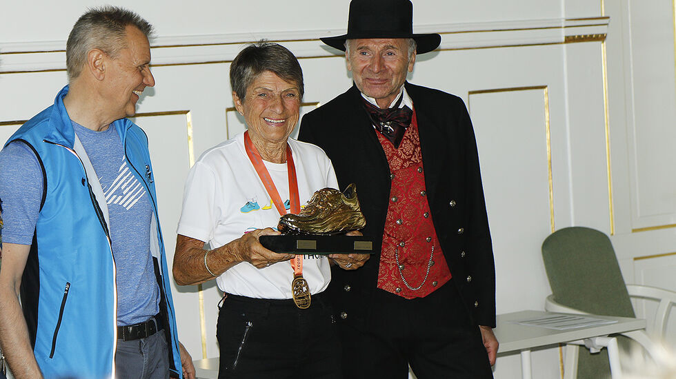 Fra Nils Hætta, som er MSM-sjef, fikk Vera Nystad overrakt gullskoen som bevis på at hun var  fjorårets beste kvinnelige veteranløper. (Foto: Turid Veggeland)