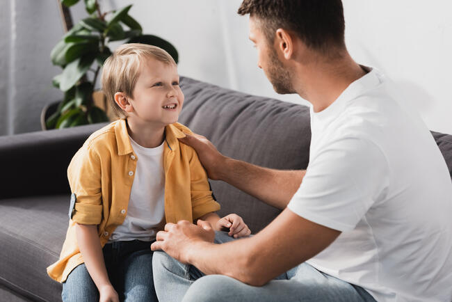 far og sønn sitter i sofaen