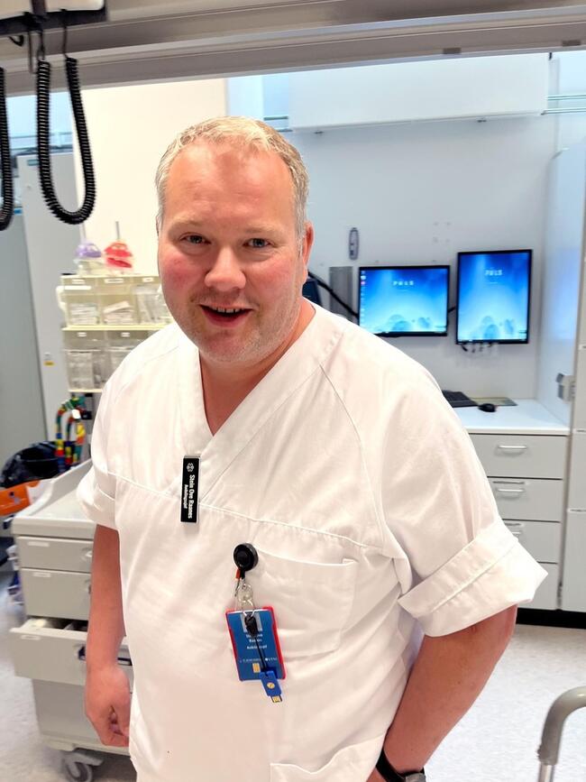 Smilende mann i sykepleierfrakk