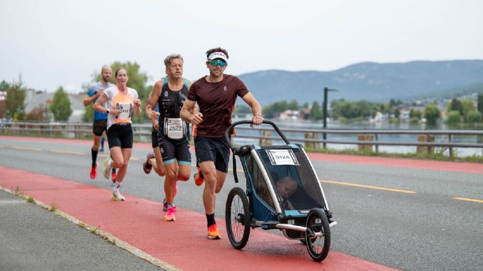 En fokusert Cato Thunes bak pacer Tommy Armani med sønnen William i vogn i hjemlige gater i Drammen søndag. (Foto: Drammen halvmaraton/Samuel Hafsahl/Aleksander Walmann)