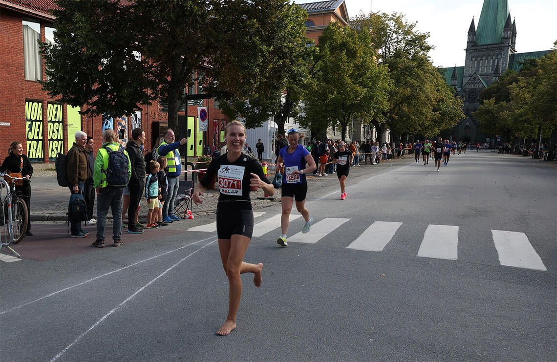 De nakne beina tok Christina Forstrønen Bruarøy trygt til mål – med et smil om munnen og Nidarosdomen i bakgrunnen. (Foto: Marianne Røhme) 