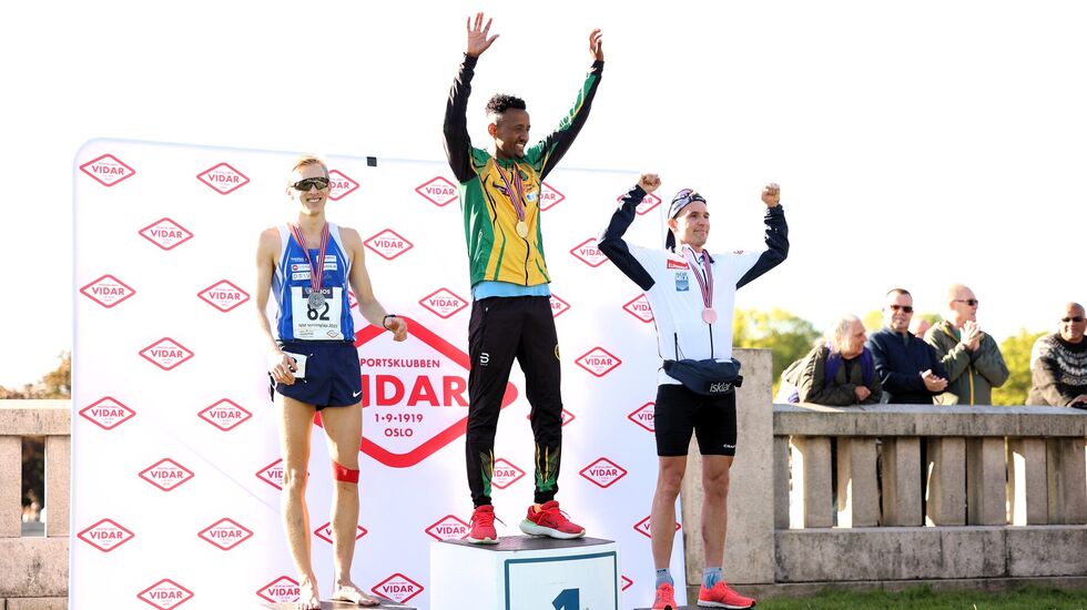 Tre meget fornøyde medaljører på seierspallen i NM lang løype 2023 (fra  venstre): Even Brøndbo Dahl, Senay Fissehatsion og Didrik Tønseth. (Foto: Samuel Hafsahl)