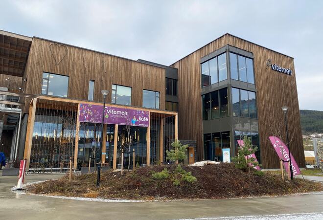 Stor trebygning med lilla banner med ViteMeir.