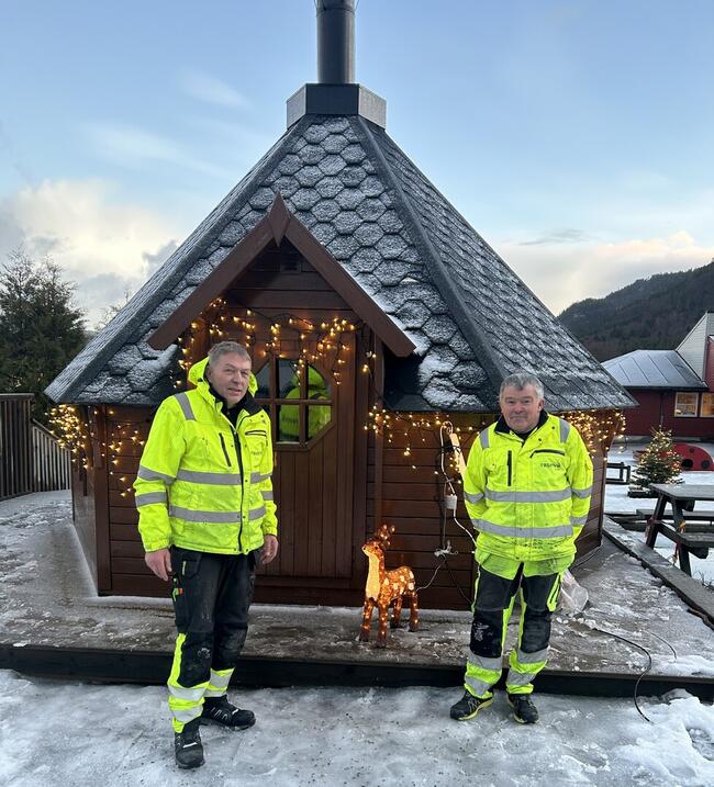 Geir Skjenald og Arnt Ove Eggan i refleksvester ved grillhytta med julelys og lysende reinsdyr.