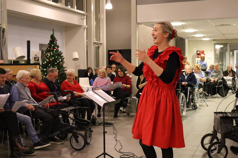 Charlotte stav står foran helsekoret og dirigerer