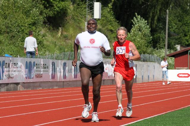 Den da 59 år gamle kenyanske storløperen Henry Rono hadde en jevn duell med den 14 år eldre Veldre-veteranen Bjørn Tvedt på 3000 m i KM i Brumunddal i 2011. Det er nok mange grunner til at de presterte på samme nivå denne dagen.... (Foto: Rolf Bakken)