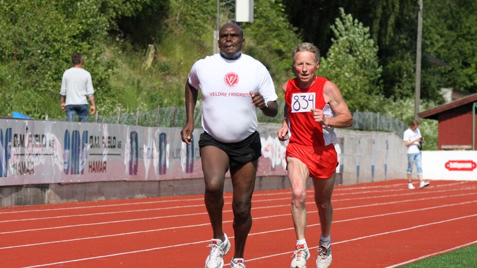 Den da 59 år gamle kenyanske storløperen Henry Rono hadde en jevn duell med den 14 år eldre Veldre-veteranen Bjørn Tvedt på 3000 m i KM i Brumunddal i 2011. Det er nok mange grunner til at de presterte på samme nivå denne dagen.... (Foto: Rolf Bakken)