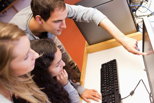 Tre ungdommer som studerer innhold på en dataskjerm