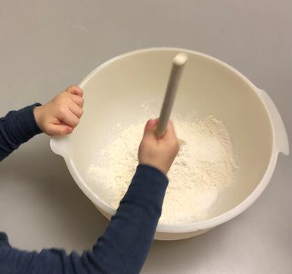 Bakebolle med barnehender som rører rundt