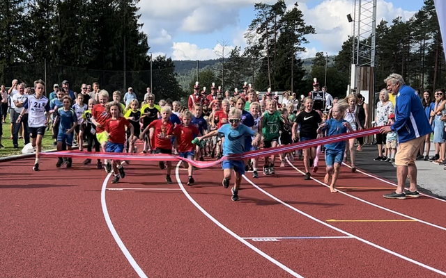 Fra åpningen av friidrettsanlegget i Birkenesparken 27. august 2022 der løpende barn fikk æren av å «løpe over startsnora» til tonene fra Birkeland Musikkorps. (Foto: Birkenes IL)