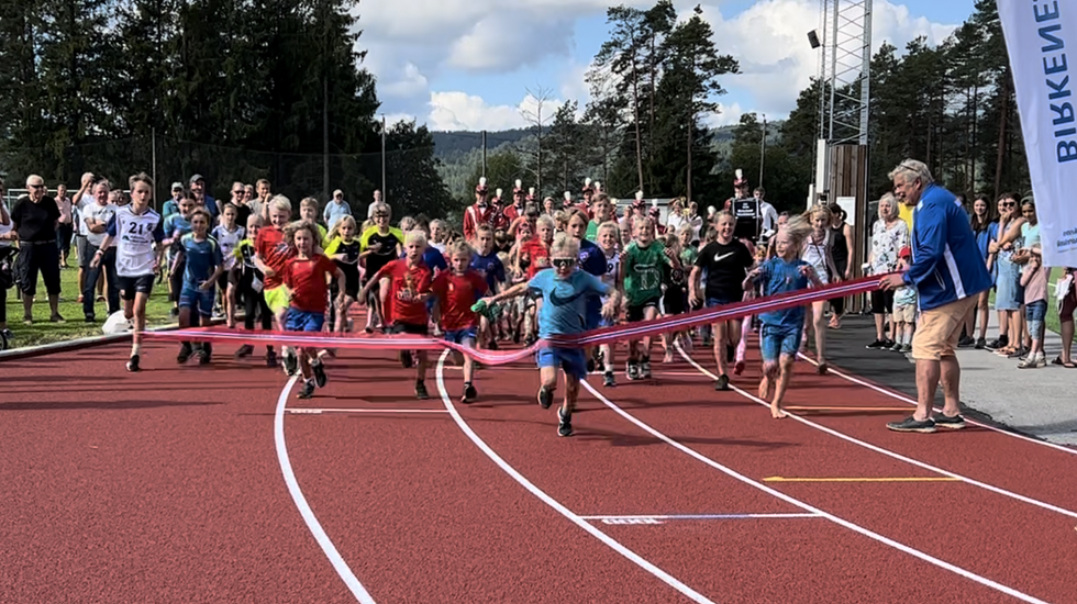 Fra åpningen av friidrettsanlegget i Birkenesparken 22. august 2022 der løpende barn fikk æren av å «løpe over startsnora» til tonene fra Birkeland Musikkorps. (Foto: Birkeland IL)