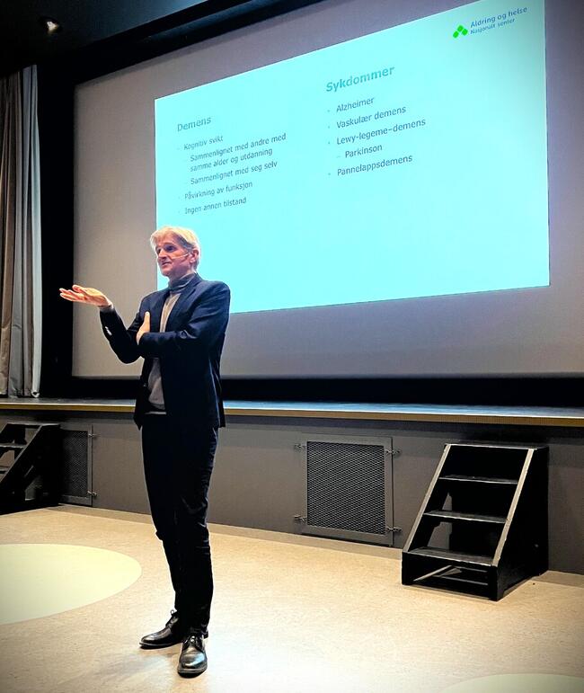 Geir Selbæk foran et lerret som viser noe av innholdet i foredraget