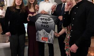 Fem personar held ei t-skjorte med påskrifta "Stao no pao".