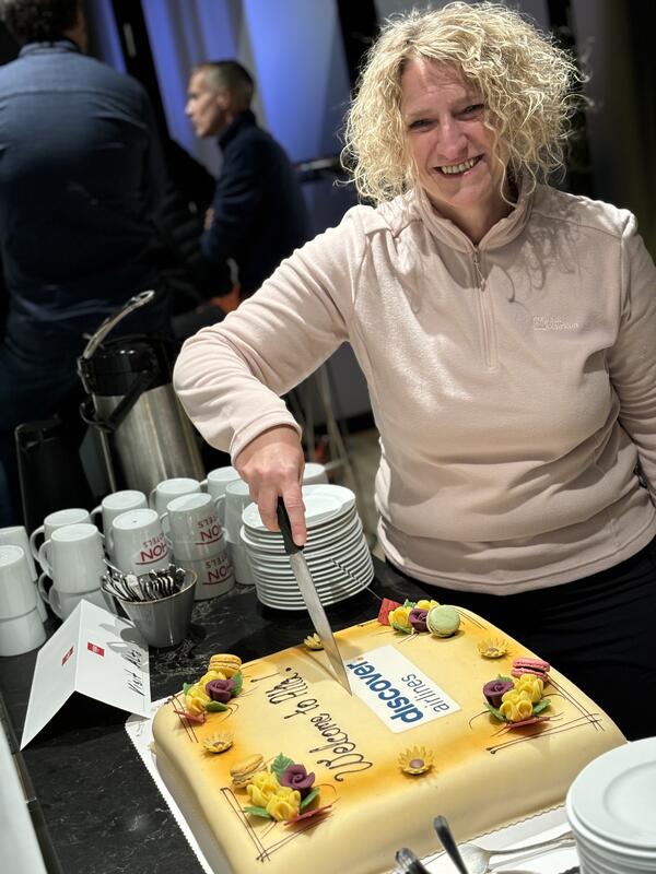 Andrea Daskulidis fra Discover Airlines åpner kaken i forbindelse med offentliggjøring av det nye rutetilbudet 16. januar 2024. Foto: Visit Alta