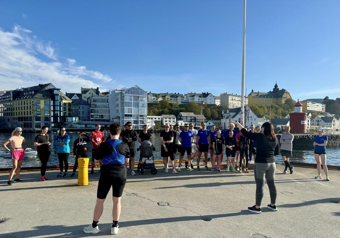 Monica Isaksen peker og forklarer løypen til Ålesund Maraton. Her fra startområdet