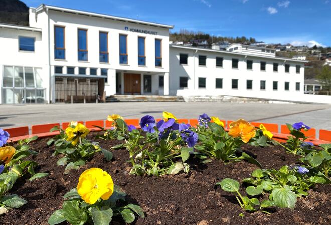 Kommunehuset i Sogndal med blomar i framgrunnen.