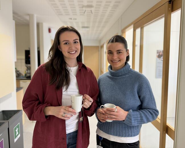 Studentene Marija Håkonsen Milovanovic og Ida Marie Mauseth holder hver sin kaffekopp, inne i Orkland rådhus. Bildet er tatt av Jonas Olsen Withbro.