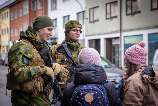 Bilde av militære i snakk med sivile