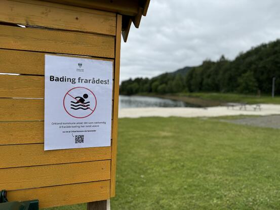 Plakat som viser at bading frarådes i Gammelosen. Denne henger ved folkehelsesenteret. Foto: Jonas Olsen Withbro/Orkland kommune