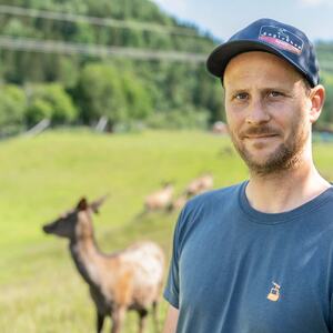 Portrett av Håkon  med hjort og grønt gress i bakgrunnen