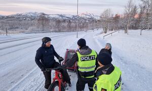 Syklist med sykkelvogn på gangvei, vinterføre og politi som kontrollerer