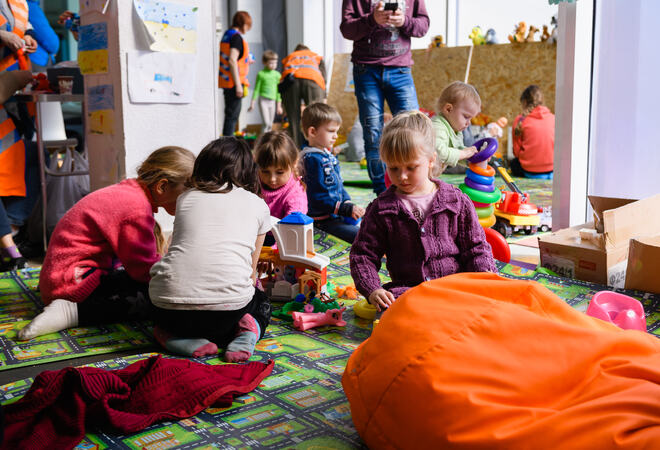 Ukrainske barn som sitter samlet på gulvet