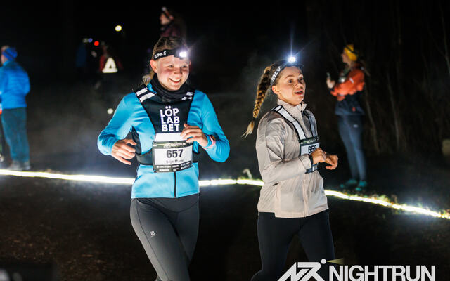 Det var mange som ønsket å prøve seg på et løp i mørket, med hodelykt. Her kommer Vilde Roko Krogstie og Mette-Mari Vea i fint driv på Nightrun Oslo. (Foto: FB-side til Nightrun)