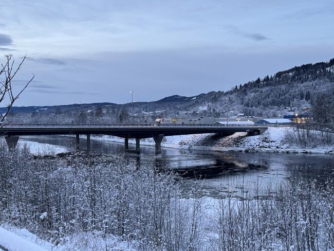 Bårdshaug bru i vinterlandskap. Strekker seg over ei elv.