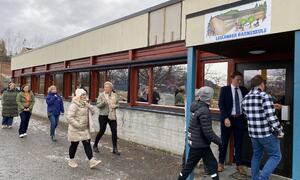 Låg murbygning. Politikarane på veg inn.