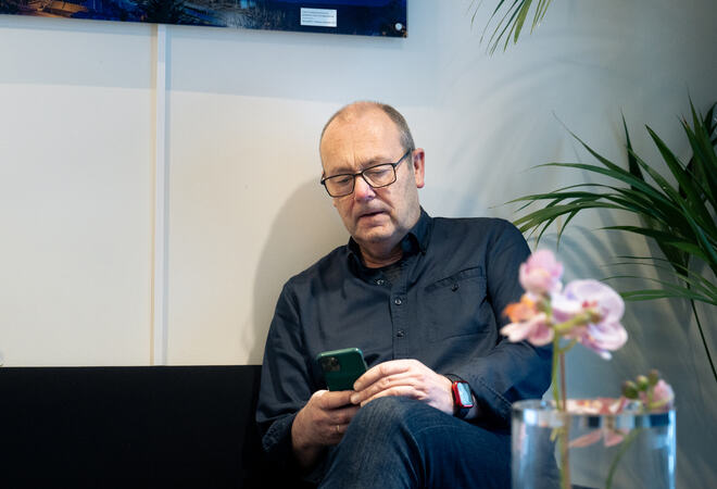 Olav Dombu studerer sin mobiltelefon