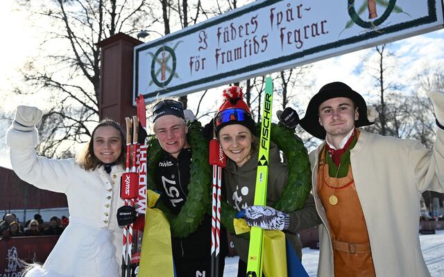 Alvar Myhlback og Stina Nilsson sammen med dagens kranskulla og kransmas under den kjente målportalen i Mora. (Foto: Arrangøren)