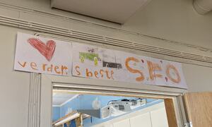 Plakat som seier verdens beste SFO med barneteikningar rundt.