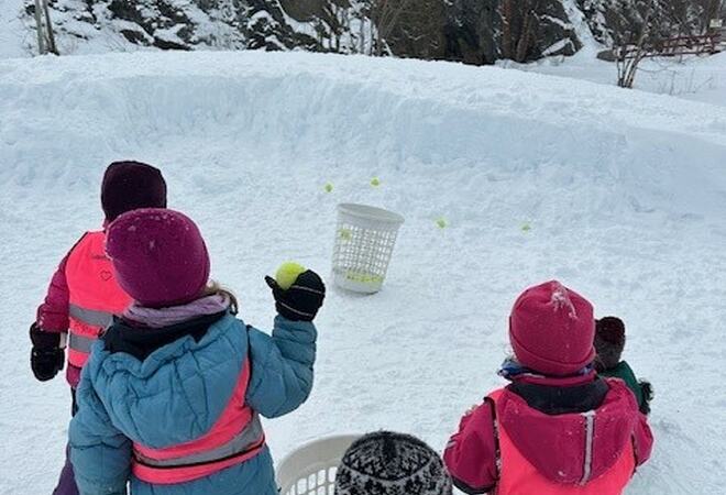 Barn kaster ball i bøtte