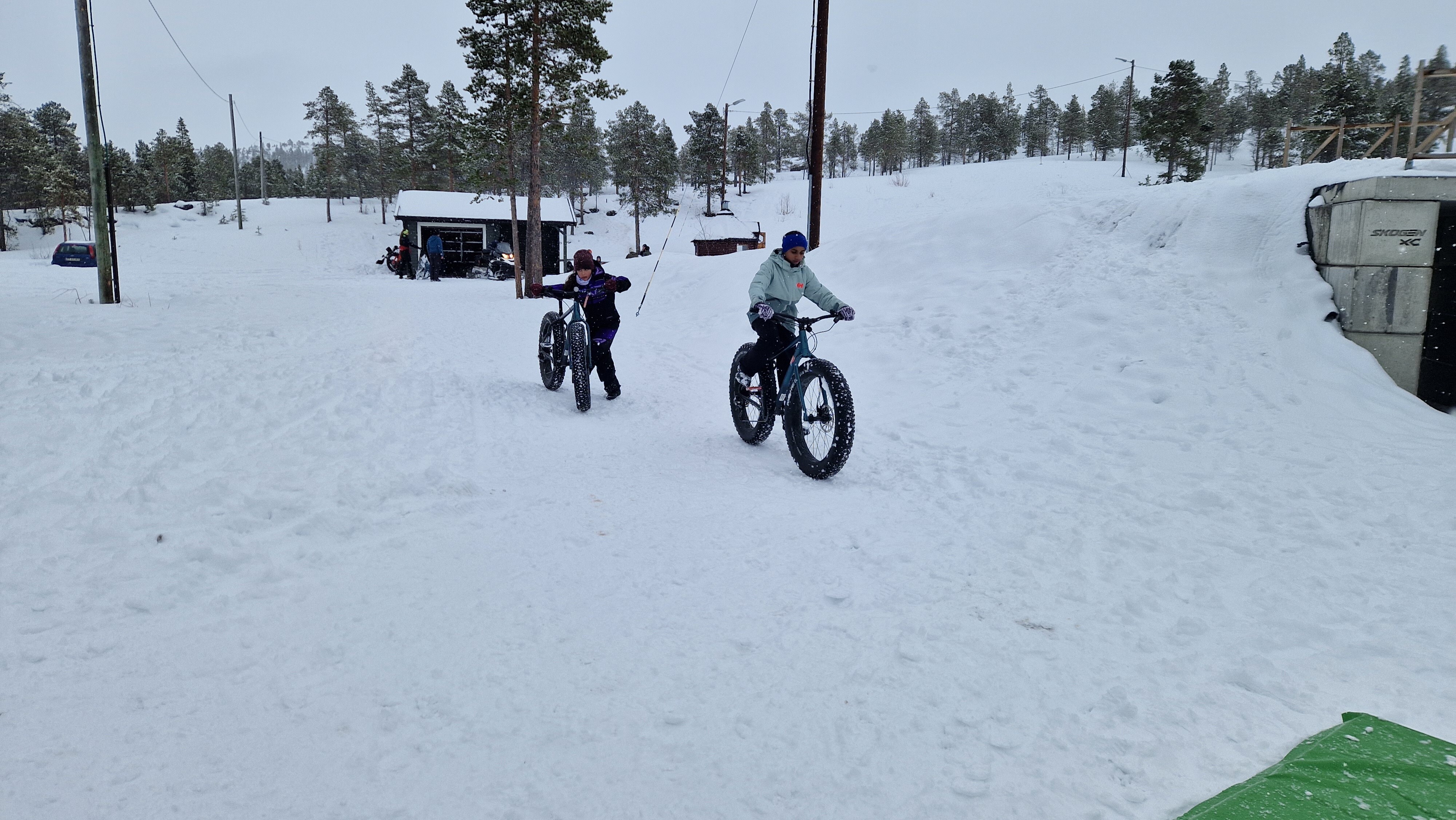 Vinter, skianlegg, fatbikesykler to jenter