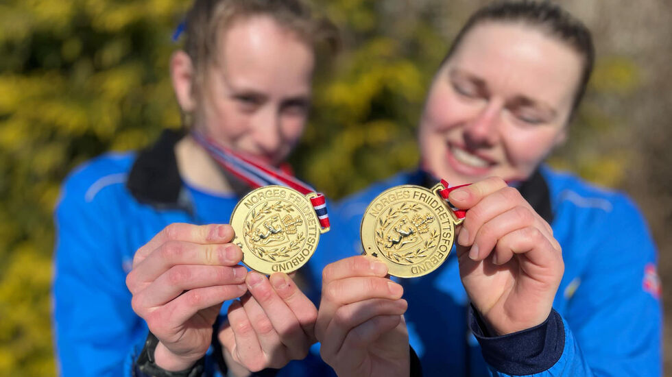 Silje Lindstad (t.h.) mener at deltakelsen i NM Terrengløp er for tynn, og dermed vil den kunne bli enda tynnere fordi ingen vil ta kostnadene med å stille. Her viser hun frem NM-gullmedaljene som hun og Bethine Riise Carlsen tok for Varegg i NM-stafetten. Der deltok det kun to lag. (Foto: Jovard Tunestveit Karlsen )