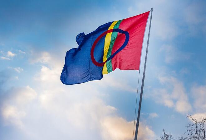 Bilde av det samiske flagget vaiende på en flaggstang