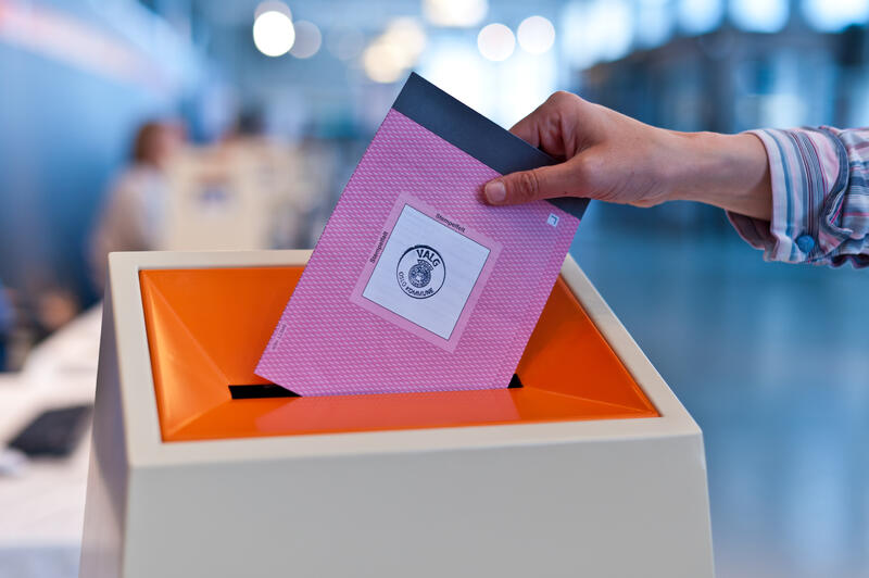 En stemmeseddel legges i en valgurne.
