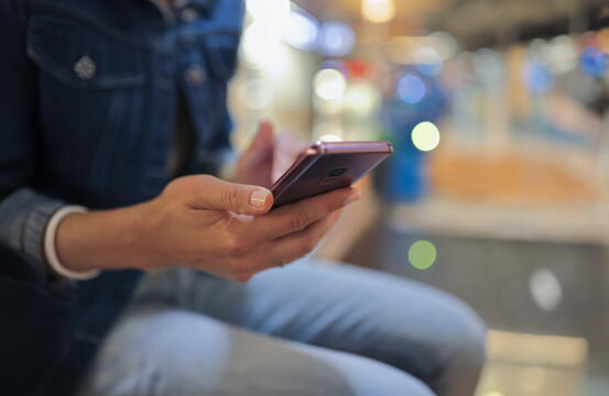 illustrasjonsfoto dame med mobiltelefon i hånden