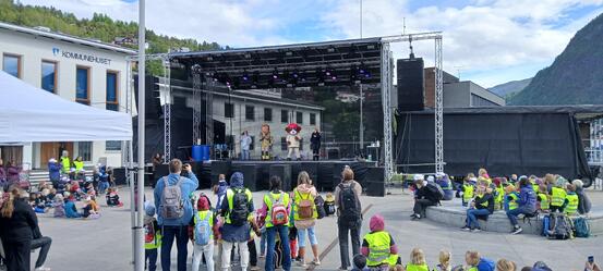 Barn og vaksne ser på show på scene framfor kommunehuset i Sogndal.