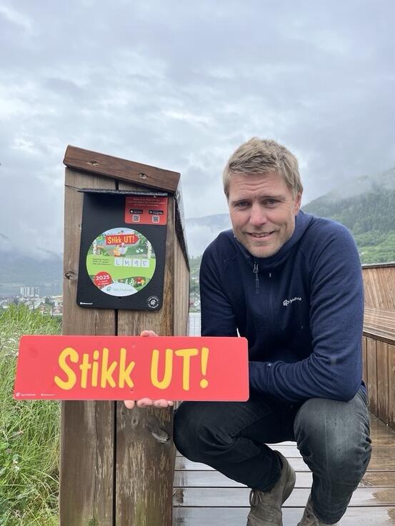 Skilt med teksten stikk ut, person som ser i kameraet.