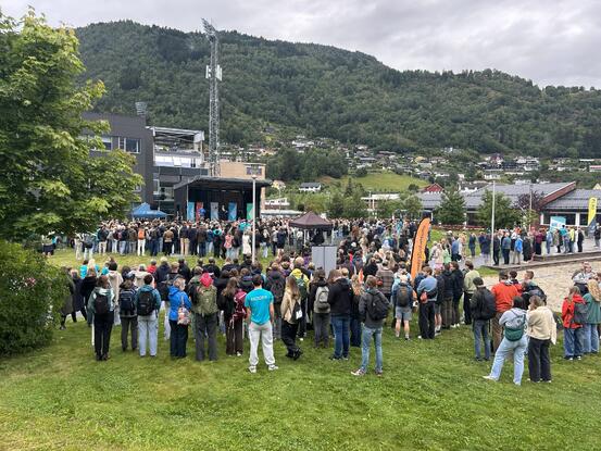 Mange folk samla framfor ei scene.